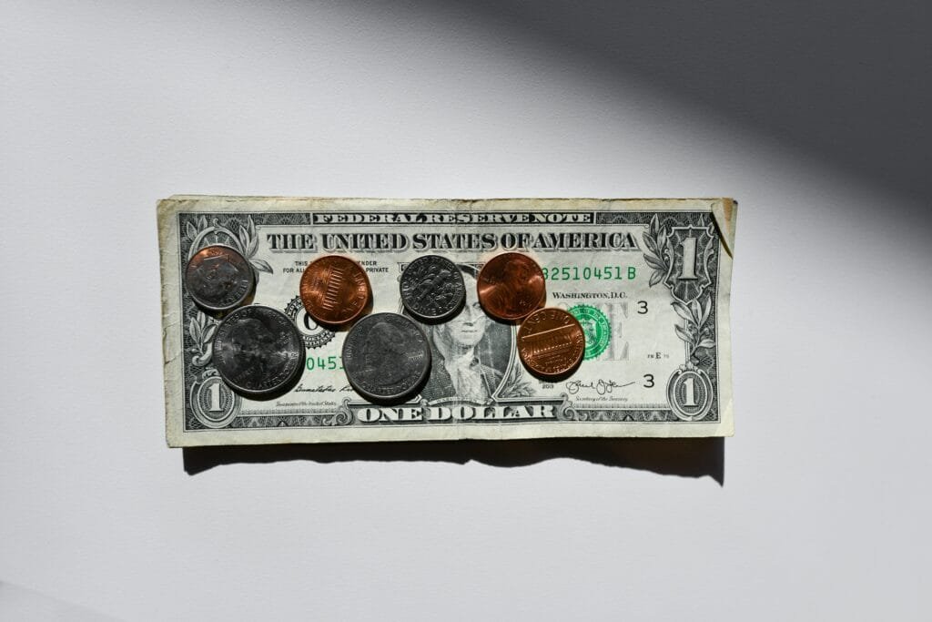 Image of money; coins on top of a dollar.